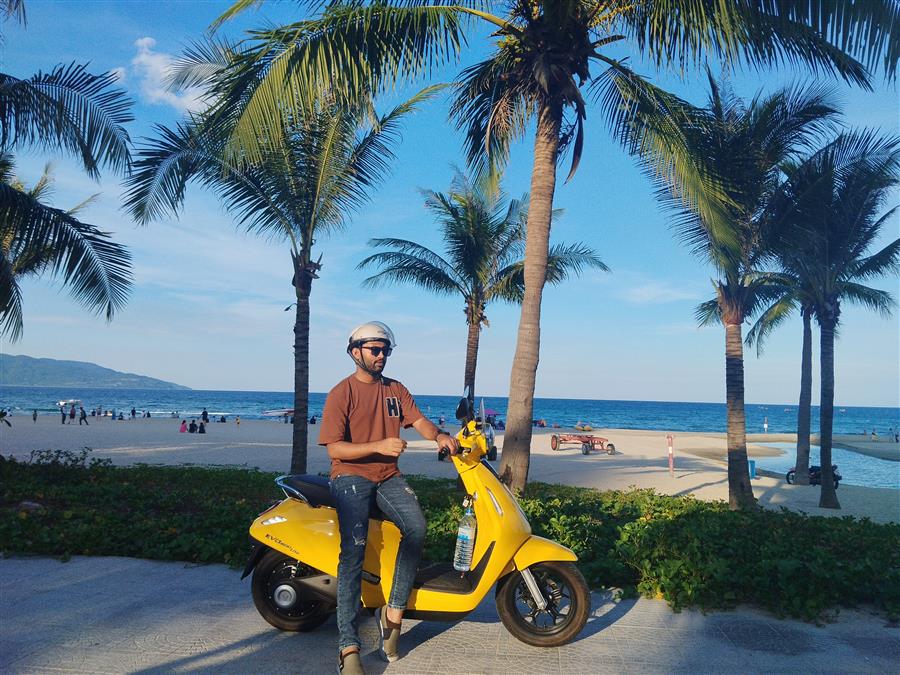Riding a scooter along a palm-lined beach in Vietnam
